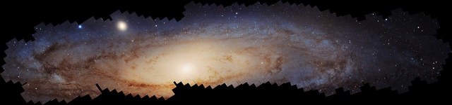 A vast panoramic Hubble mosaic of the Andromeda Galaxy, showing its bright central region, dense fields of stars, dark dust lanes, and bluish star-forming regions stretching across the galaxy.