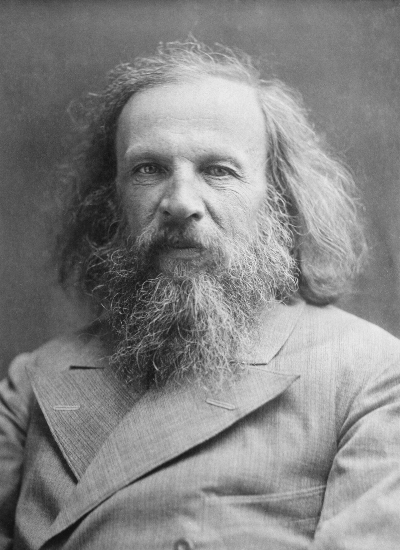 Black-and-white portrait photograph of Russian chemist Dmitri Mendeleev, shown with long hair and a full beard.